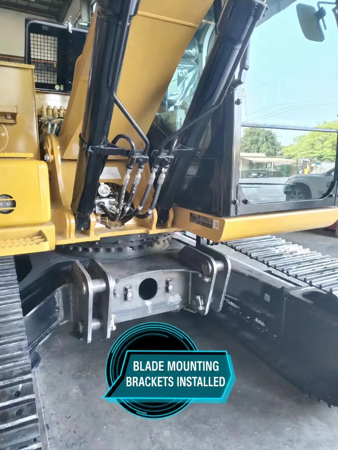 Blade mounting brackets on the CAT 313 GC lower frame between the tracks.
