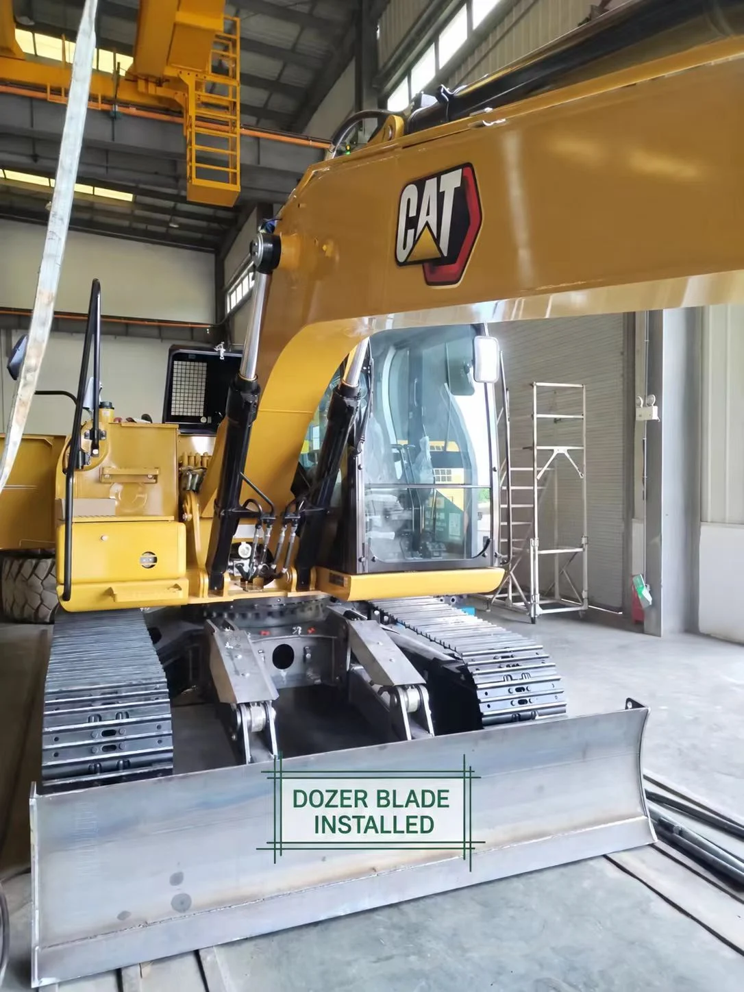 Front-mounted dozer blade and two hydraulic cylinders on the CAT 313 GC.