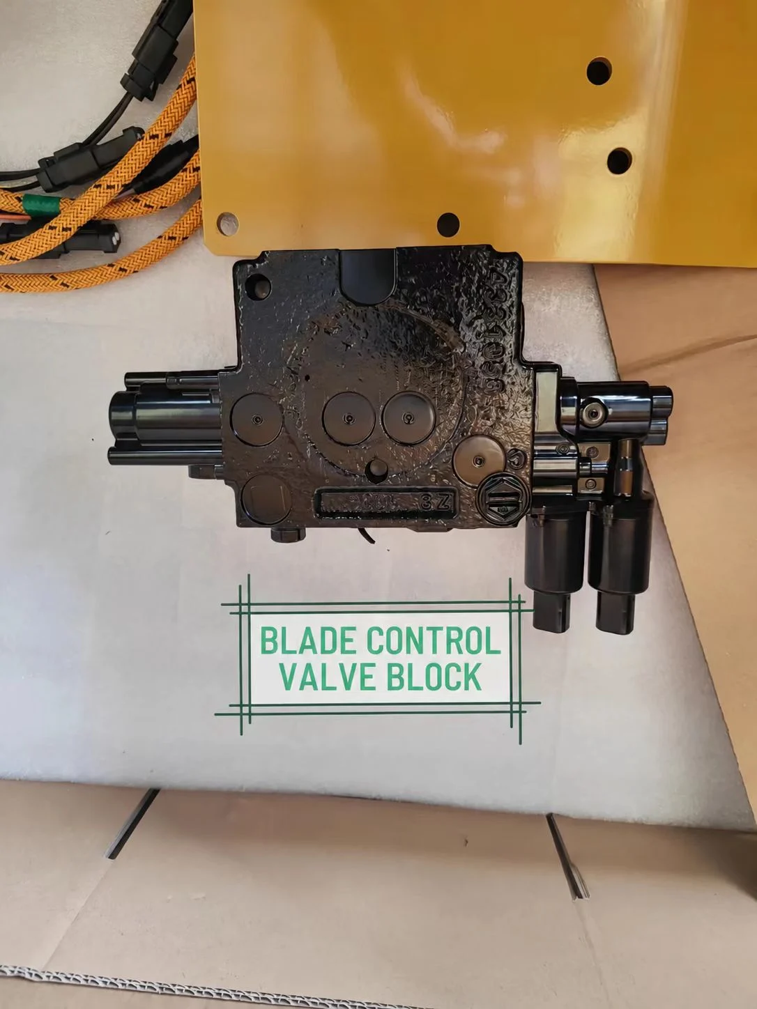 Blade control valve block and mounting plate laid out before fitting.