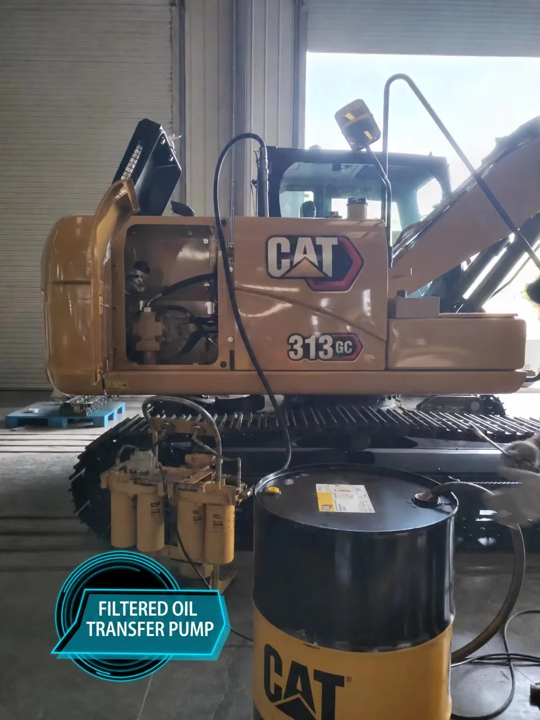 Oil-transfer pump and filter assembly connected to a drum beside the CAT 313 GC.